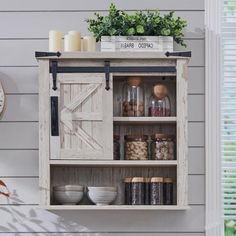 an old wooden cabinet with glass doors and shelves on the wall next to a clock