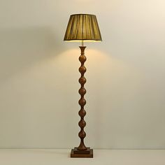 a lamp that is on top of a table next to a white wall and floor