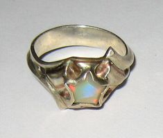 NATURAL SOLID AUSTRALIAN OPAL (HYDROPHANE CRYSTAL) IN STERLING SILVER RING WITH BRASS AND COPPER DETAILS   RING DETAIL INSPIRED BY WONDER WOMAN SIZE ~ 6.5 SETTING height ~ 5mm BAND width ~ 4.3mm STONE DETAIL SIZE ~ 7mm PENTAGON NATURAL SOLID AUSTRALIAN CRYSTAL OPAL  THIS ONE OF A KIND (NEVER CAST) SILVER RING HAS A LOW PROFILE DESIGN TO PREVENT CATCHNG AND SNAGGING. INSPIRED BY WONDER WOMAN MADE WITH THE "PERSON ON THE GO" IN MIND. WE BELIEVE YOU DON'T HAVE TO SACRAFICE FUNCTION FOR FASSION SO L Galaxy Jewelry Rings, Opal Star Ring, Stone Setting Jewelry Design, Resin And Metal Jewelry, Raw Silver Jewelry, Soldered Metal Jewelry, Weird Wedding Rings, Silver Clay Ring, Selenite Ring