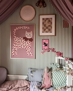 a child's bedroom decorated in pink and green with pictures on the wall above it