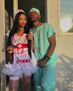 a man standing next to a woman dressed as a nurse in front of a building