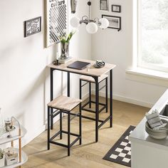 a table and stools in a room with pictures hanging on the wall above them