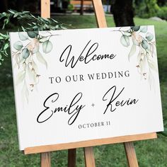 a welcome sign is on an easel in the grass