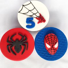 three spiderman cupcake toppers sitting on top of each other in front of a white background