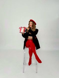 a woman sitting on a chair with a cake in her hand and wearing red tights