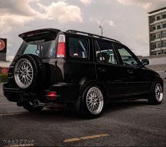 a small black car parked in a parking lot