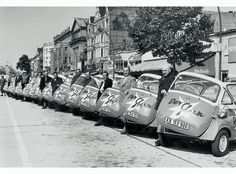 a row of small cars parked next to each other on the side of a road