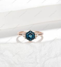 an engagement ring with a blue topazte stone and three diamonds on the side