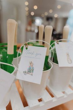 buckets filled with green plastic cups sitting on top of a table