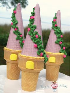 three ice cream cones decorated with pink flowers and green leaves