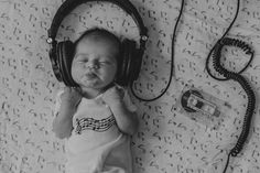 a baby wearing headphones laying on top of a bed