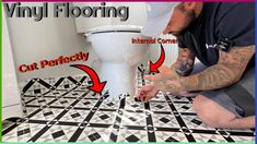 a man kneeling down next to a toilet in a room with black and white tiles