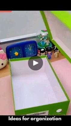 an open green box sitting on top of a counter next to other items and toys