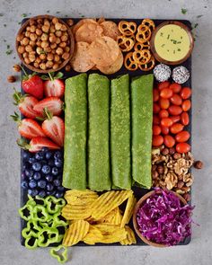 a platter filled with vegetables, fruits and dips on top of a table