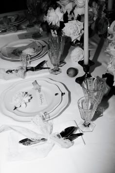 the table is set with flowers, candles and plates for an elegant dinner party or special occasion