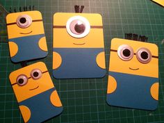 three yellow and blue despicaded minion magnets sitting on top of a green cutting board