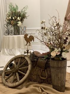 an old wooden wagon with flowers in it sitting on the ground next to a table