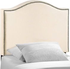 an upholstered headboard with beading and pillows