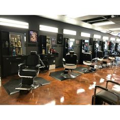 a hair salon with lots of chairs and mirrors