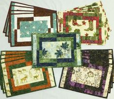 quilted placemats and coasters are laid out on a white tablecloth