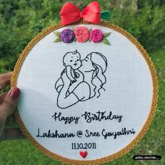 someone is holding up a embroidered birthday ornament with the image of a kissing couple