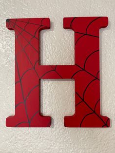 the letter h is painted red and has a spider web pattern on it's side