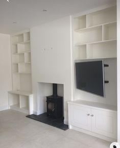 an empty living room with a fireplace and bookshelves