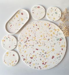 the plates are decorated with confetti and gold leaf designs on them, along with other decorative items