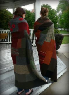 two women standing on the porch with their back to each other, wrapped in blankets