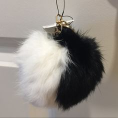 a black and white fur keychain hanging from a hook