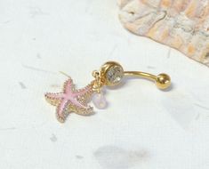 Starfish Belly Ring Show off your beautiful belly! Belly ring features a textured golden starfish charm with sparkly pink enamel accented with a hand wire wrapped pink agate bead. Belly button ring measures 1 3/4 inches long total length. Barbell is 14g gold plated surgical steel with a 10mm wearable bar length. For Belly Button Rings: https://www.etsy.com/shop/AllAboutClass?section_id=18474235&ref=shopsection_leftnav_1 For Industrial Barbells: https://www.etsy.com/shop/AllAboutClass?ref=l2- Starfish Belly Button Ring, Cute Belly Ring, Pink Starfish Jewelry For Gift, Pink Starfish Charm Jewelry, Pink Star Jewelry With Starfish Charm, Pink Star-shaped Jewelry With Starfish Charm, Belly Pericing, Summer Belly Rings, Cute Belly Button Piercing