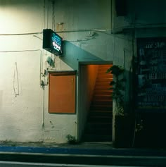 an entrance to a building with a sign on the wall and stairs leading up to it