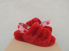 UGG FLUFF YEAH SLIDE SLIPPERS ~ NEW IN BOX WOMEN'S SIZE US 11/ EUR 42/ UK 9 ~ FITS US 11-11.5/ EUR 42-42.5/ UK 9-9.5  STYLE # 1095119  COLOR: RIBBON RED ~MY ITEMS ARE ALWAYS AUTHENTIC, PLEASE SEE MY TRUSTED FEEDBACK Both indoor and outdoor use Fully covered and lined with sheepskin Stretch UGG logo heel strap Genuine sheepskin UGG logo sock liner ( insole) that naturally wicks away moisture and helps keep your feet dry, warm and cozy 1 1/2" sole with a rubber bottom Please see the pictures for m Fluff Yeah Slide, Ugg Slides, Red Slippers, Sheepskin Slippers, Slide Slippers, Ugg Slippers, Kids Uggs, Liner Socks, Slipper Sandals