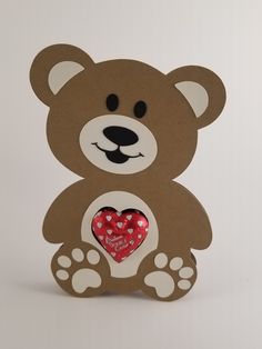 a brown teddy bear holding a red heart