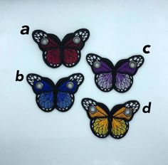 three butterflies with different colors and letters on them