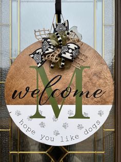 a welcome sign hanging on the front door to someone's dog house with their monogrammed name