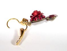 a pair of scissors with some red crystals on it's end and a gold hook