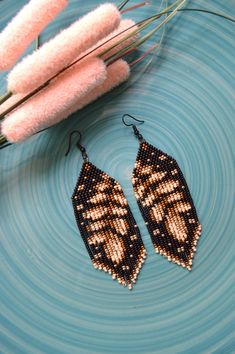 a pair of beaded earrings sitting on top of a blue plate