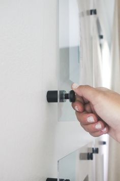 a person is holding onto the handle of a door with two knobs on it