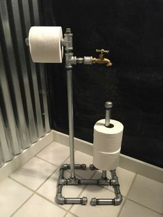 two rolls of toilet paper sitting on top of metal pipes in a bathroom next to a radiator