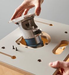 a person using a sanding machine on top of a piece of wood with holes in it