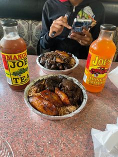 a person sitting at a table with some food and drinks