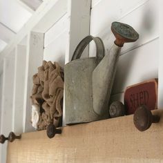 an old watering can is sitting on a shelf