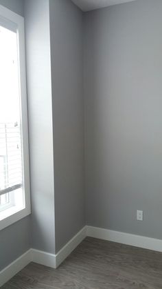 an empty room with gray walls and white trim