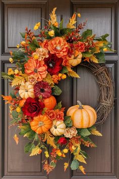 a wreath with flowers and pumpkins hanging on the front door to decorate it for fall