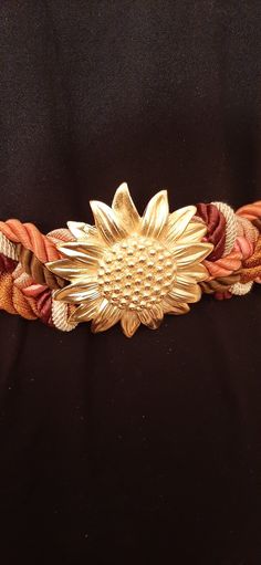 "This is a vintage fabric belt by Ione, this belt is from the 80's.  This is a jewel tone belt with a Sunflower on the front with orange, pink, white and brown braided  cording with Velcro strip in the back for closing.  The center piece is a metal sunflower. The belt is in very good condition, no tears, pulls or discoloration on the belt.  The belt has braided fabric strap interwound into the belt in the front.    This belt closes with hook & loop tape and is sized for Small, Medium and Large a Metal Sunflower, Vintage Rocking Chair, Braided Fabric, Hook And Loop Tape, Fabric Strap, Vintage Belt, Vintage Belts, Fabric Belt, Suspender Belt