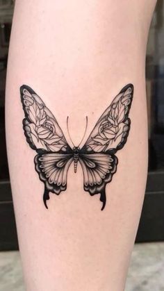 a black and white butterfly tattoo on the leg