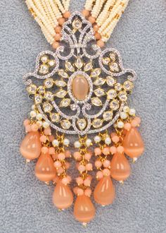 This beautiful necklace set in Peach boasts a premium quality dual-tone Tyaani with intricate Kundan detailing. It's the ideal accessory to add a touch of glamour to any special occasion, such as a runway show. Don't let this exquisite piece slip away! Necklace Length: 15" Neckline has an adjustable doori. Earring Lenght: 3.5" Push-Back closure Weight : 23 gms each. Dual-tone finish on high-quality brass as a base metal. Availability: In-Stock. *Color may vary slightly due to light condition & p Orange Pendant Jewelry For Wedding, Orange Jewelry For Wedding And Diwali, Elegant Peach Jewelry For Festive Occasions, Orange Festive Jewelry For Celebration, Festive Orange Jewelry For Celebration, Orange Festive Celebration Jewelry, Kundan Mala, Phone Items, Mala Necklace