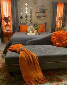 a living room with orange and gray decor on the walls, couches and mirrors