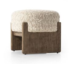 the foot stool is made out of wood and sheepskins, with an upholstered cushion